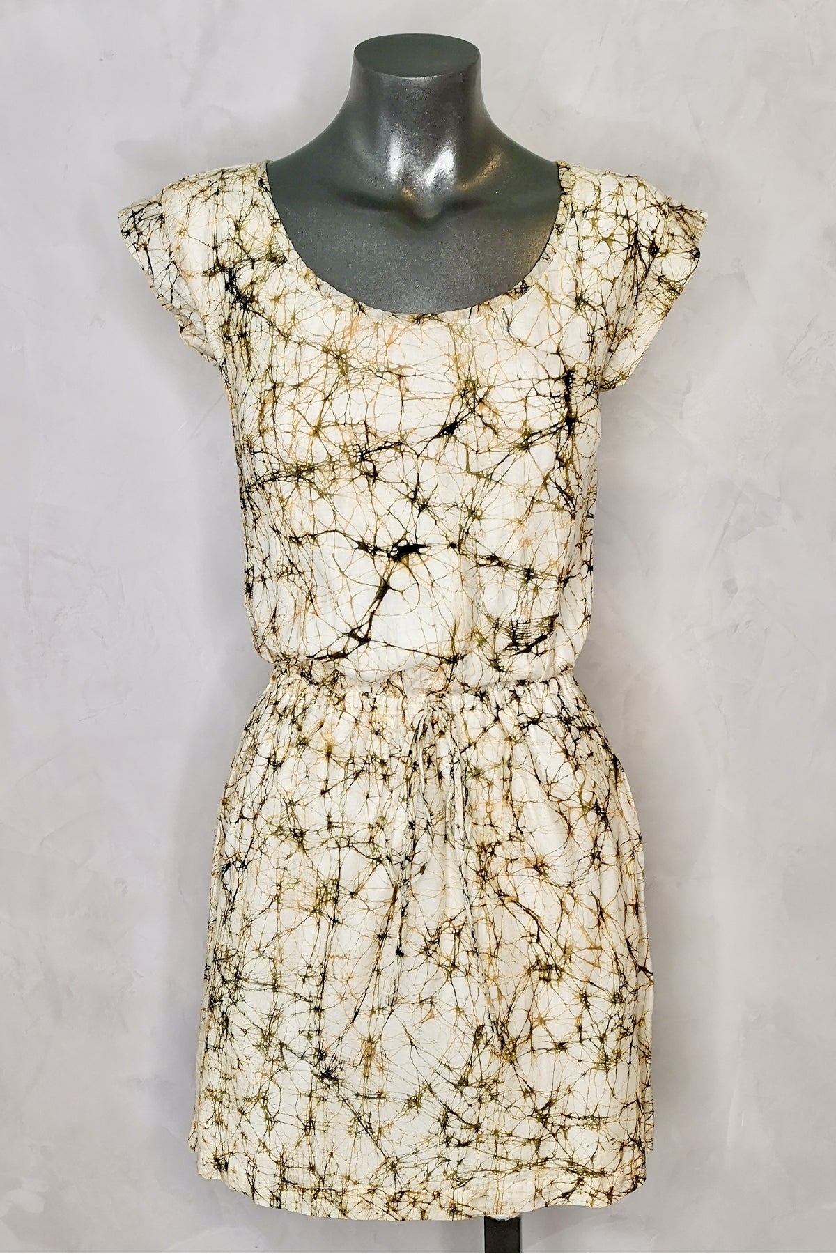 Vestido corto Wren en maniquí, visto de frente sobre fondo blanco, resaltando el corte entallado y color tierra