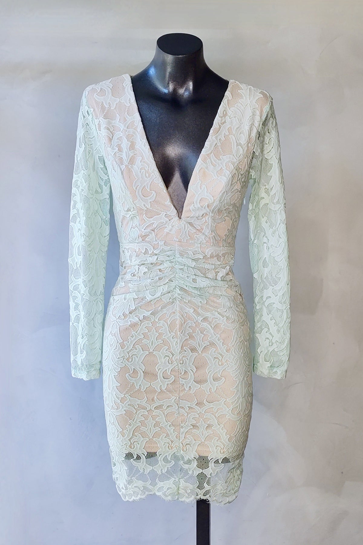 Imagen del vestido midi de encaje Angel Biba en verde menta en maniquí con fondo blanco, mostrando la caída fluida y silueta trasera