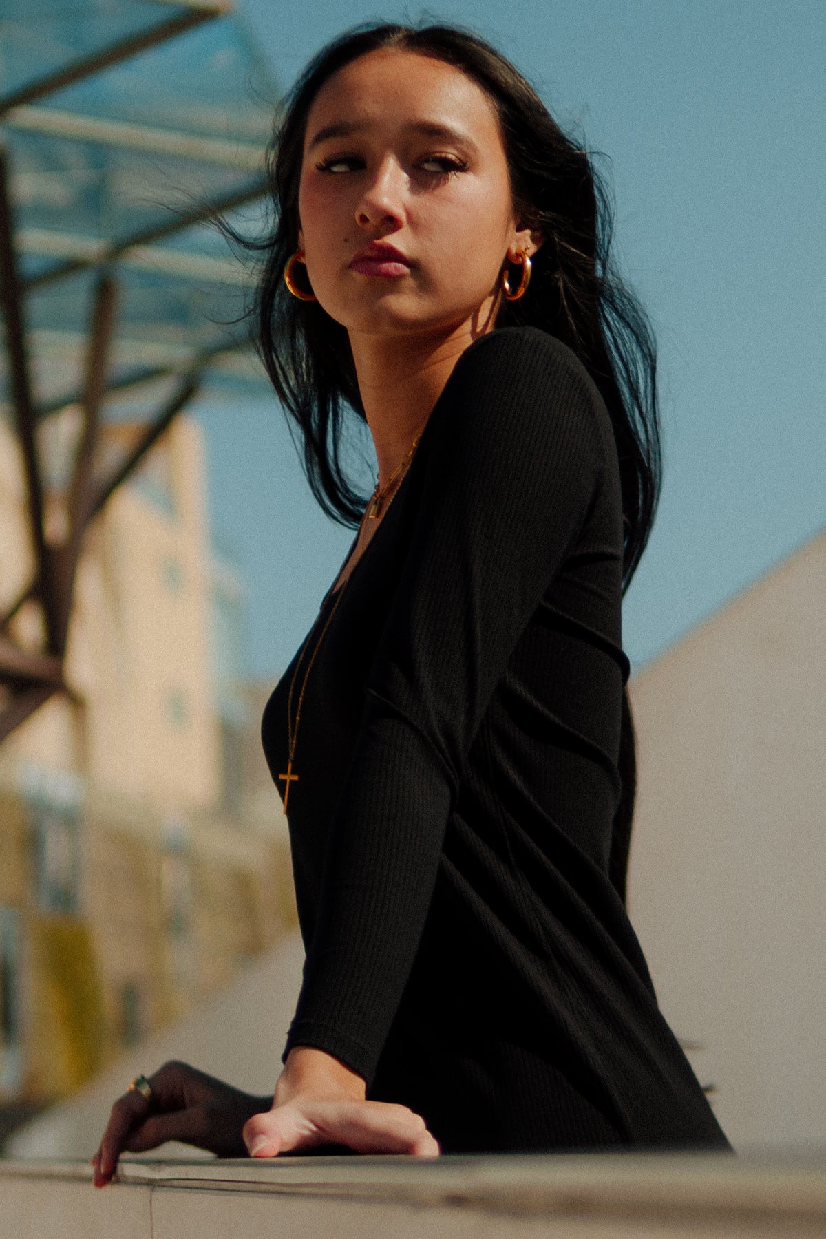 Primer plano en blanco y negro de la modelo apoyada con vestido midi Vila rojo, destacando detalles del tejido canalé