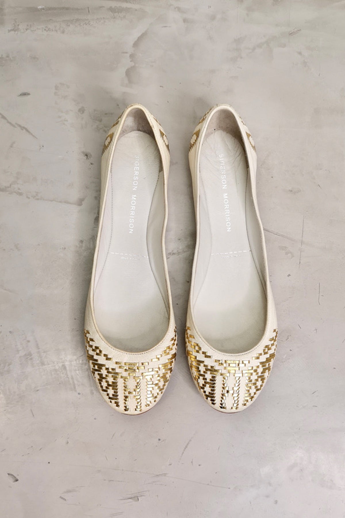 Vista superior de la bailarina Sigerson Morrison en piel blanca con bordados dorados, diseño cómodo y elegante para uso diario