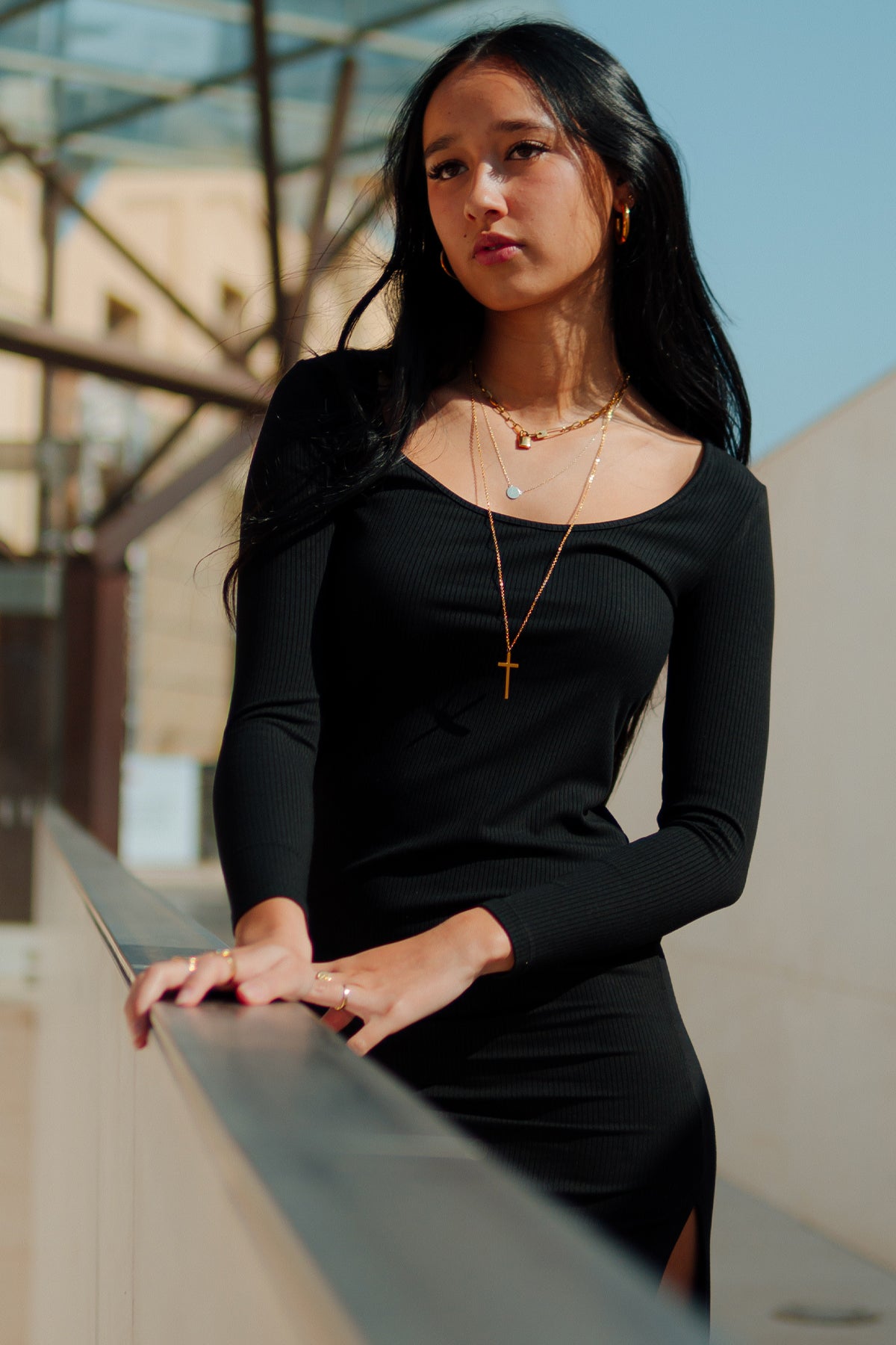 Modelo posando frontalmente apoyada con vestido midi negro Vila, resaltando el diseño y caída del tejido