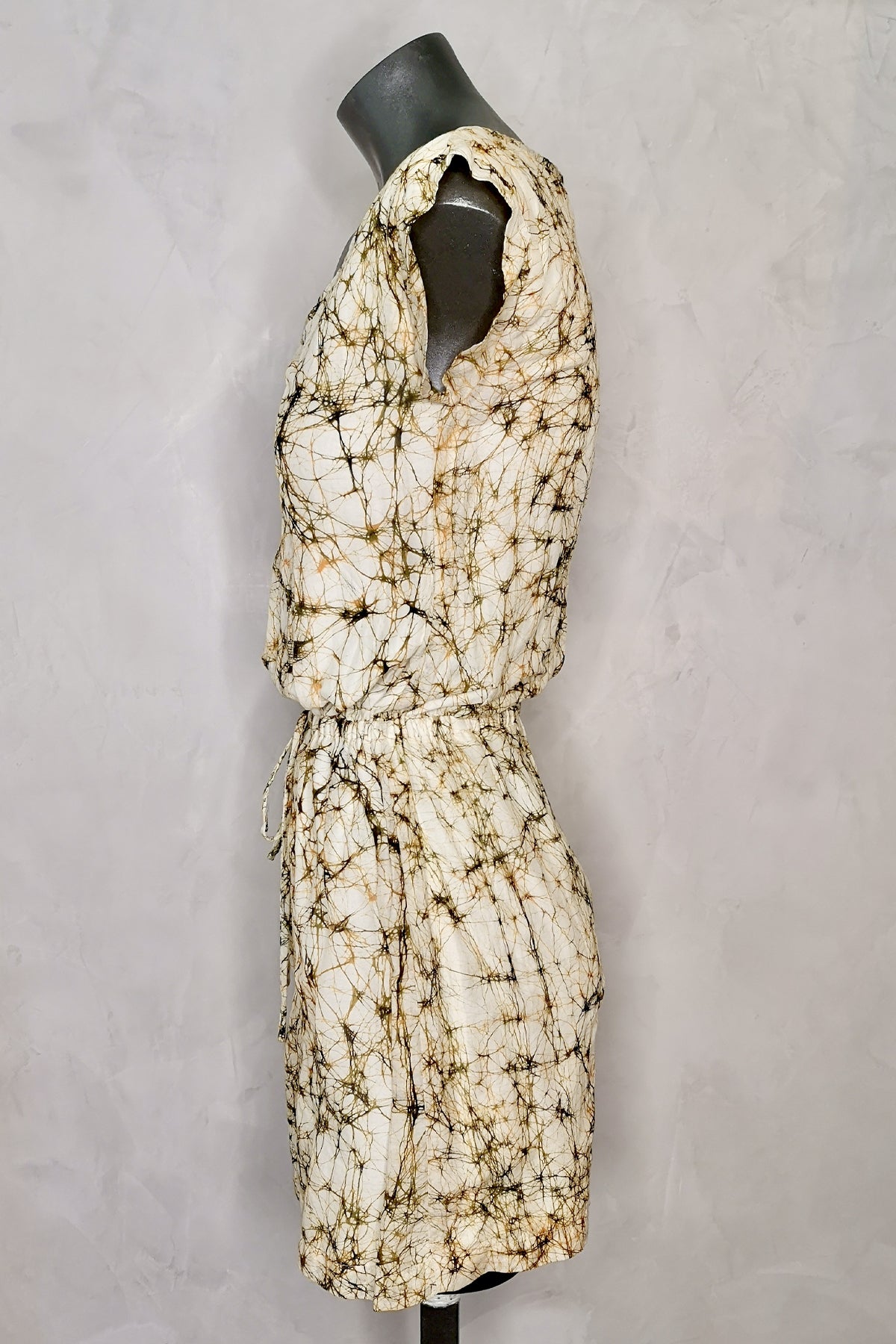 Vestido corto Wren en maniquí visto de perfil sobre fondo blanco, mostrando el corte ajustado y los detalles laterales del diseño