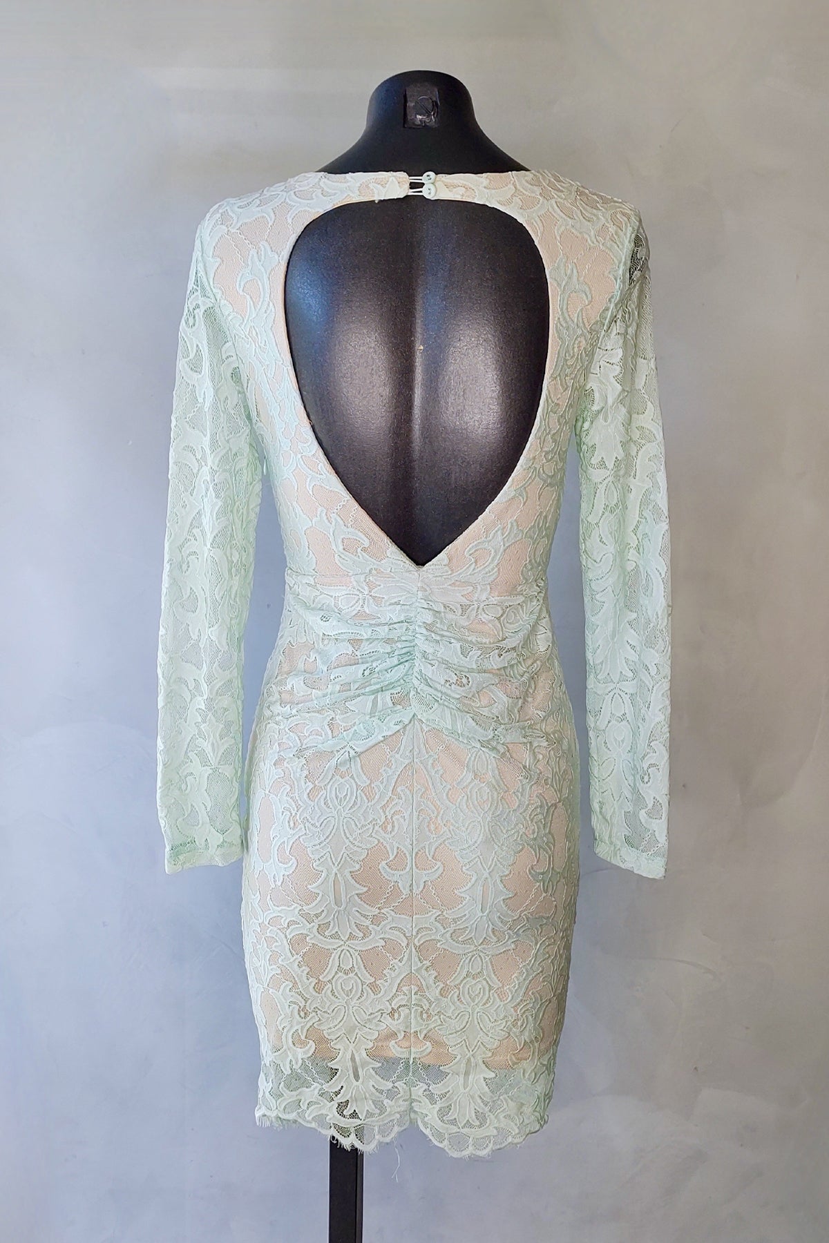 Vista trasera del vestido midi Angel Biba en verde menta sobre maniquí con fondo blanco, mostrando encaje y caída fluida