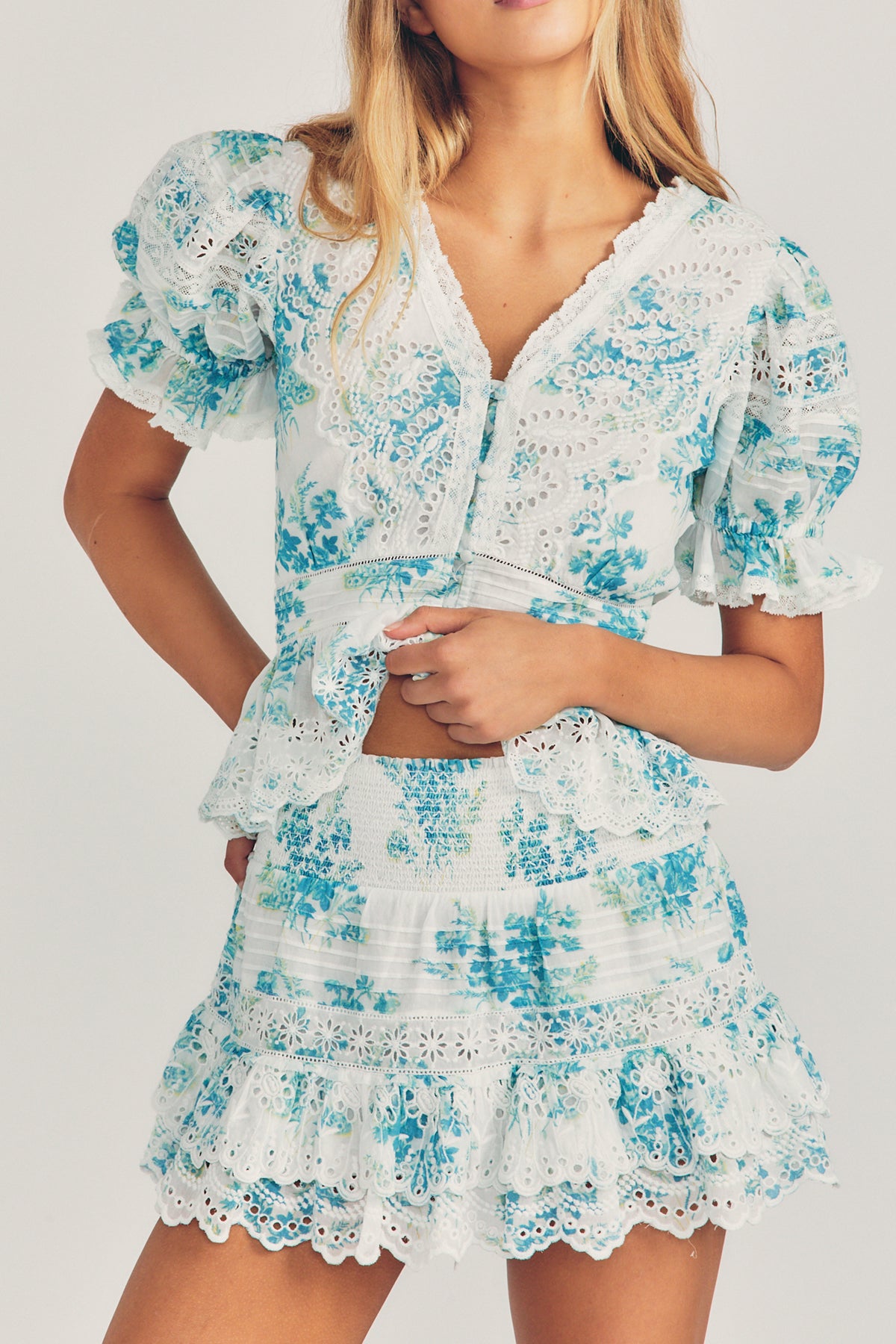 Modelo luciendo la falda Jimena en color turquesa con cinturilla fruncida y bordado de encaje floral sobre fondo neutro