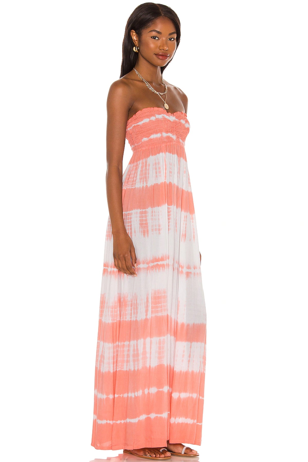 Vista lateral del vestido largo Seaside de Tiare Hawaii en modelo mostrando fluidez y colores vivos en ambiente natural