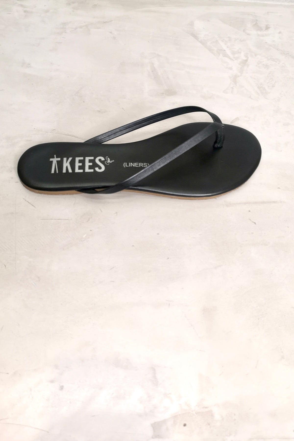 Chancla Tkees Black Flip Flop negra vista desde arriba, mostrando el diseño fino y elegante de su forma minimalista
