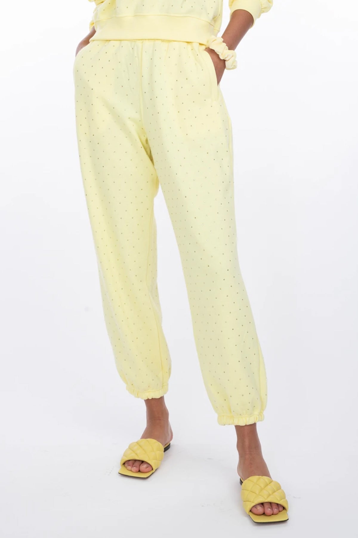 Foto de la modelo de frente con los pantalones Rena Crystal, enfatizando la caída fluida y estilo moderno en amarillo claro