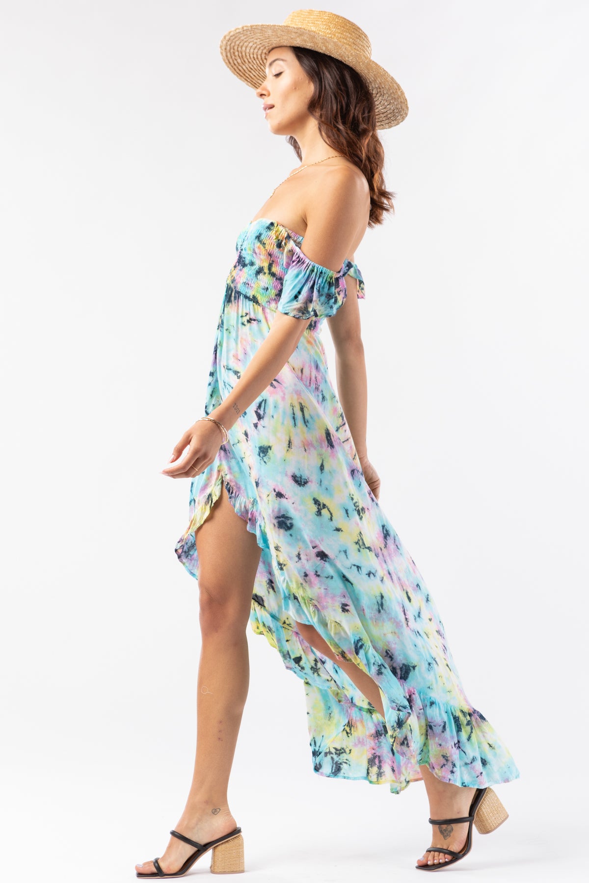 Modelo posando en vista lateral con vestido maxi Tiare Hawaii Brooklyn en degradado rosa, amarillo y azul con estilo bohemio