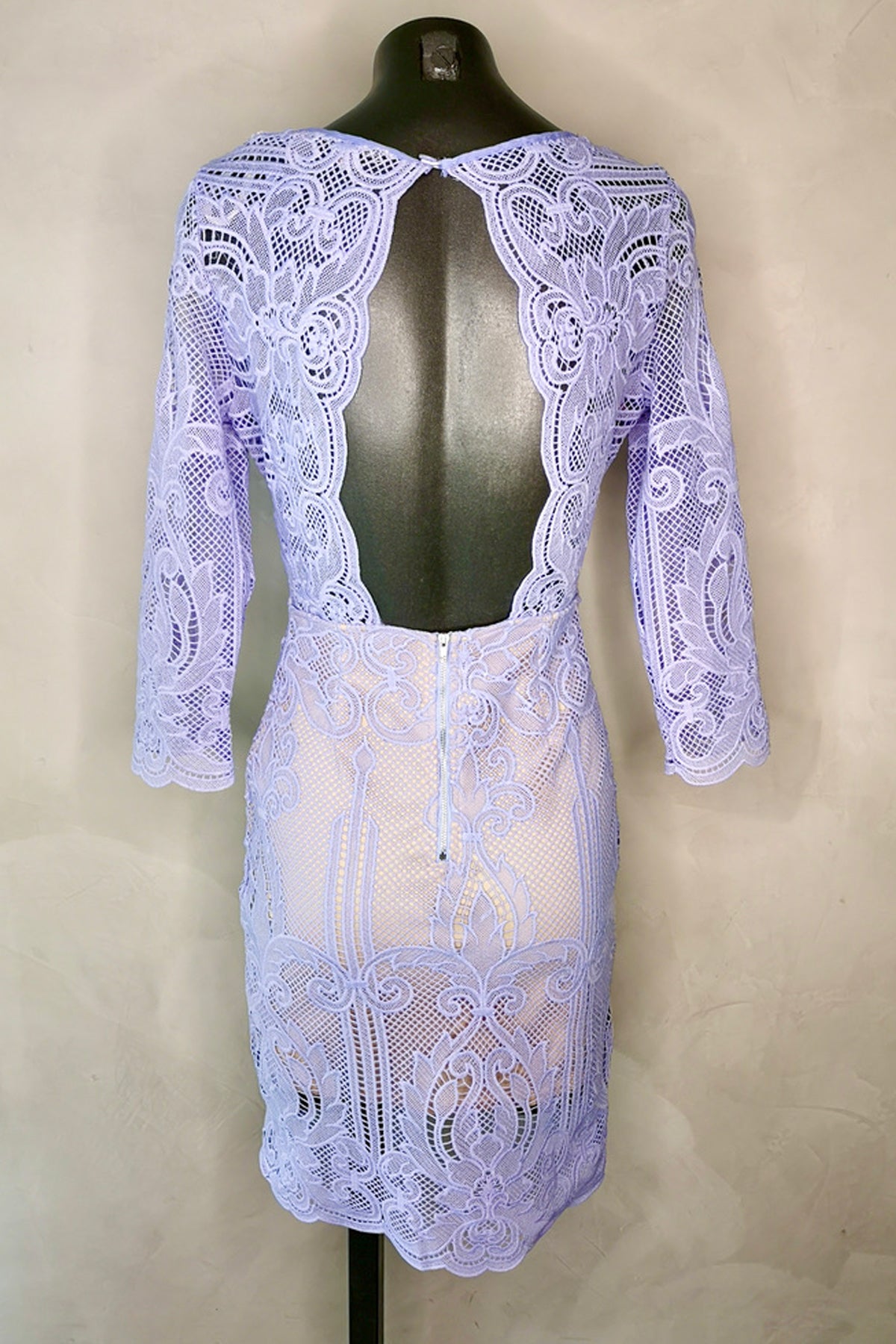 Vista trasera del vestido midi V Neck Lace Angel Biba en color lavanda sobre maniquí y fondo blanco, destacando espalda abierta y caída elegante