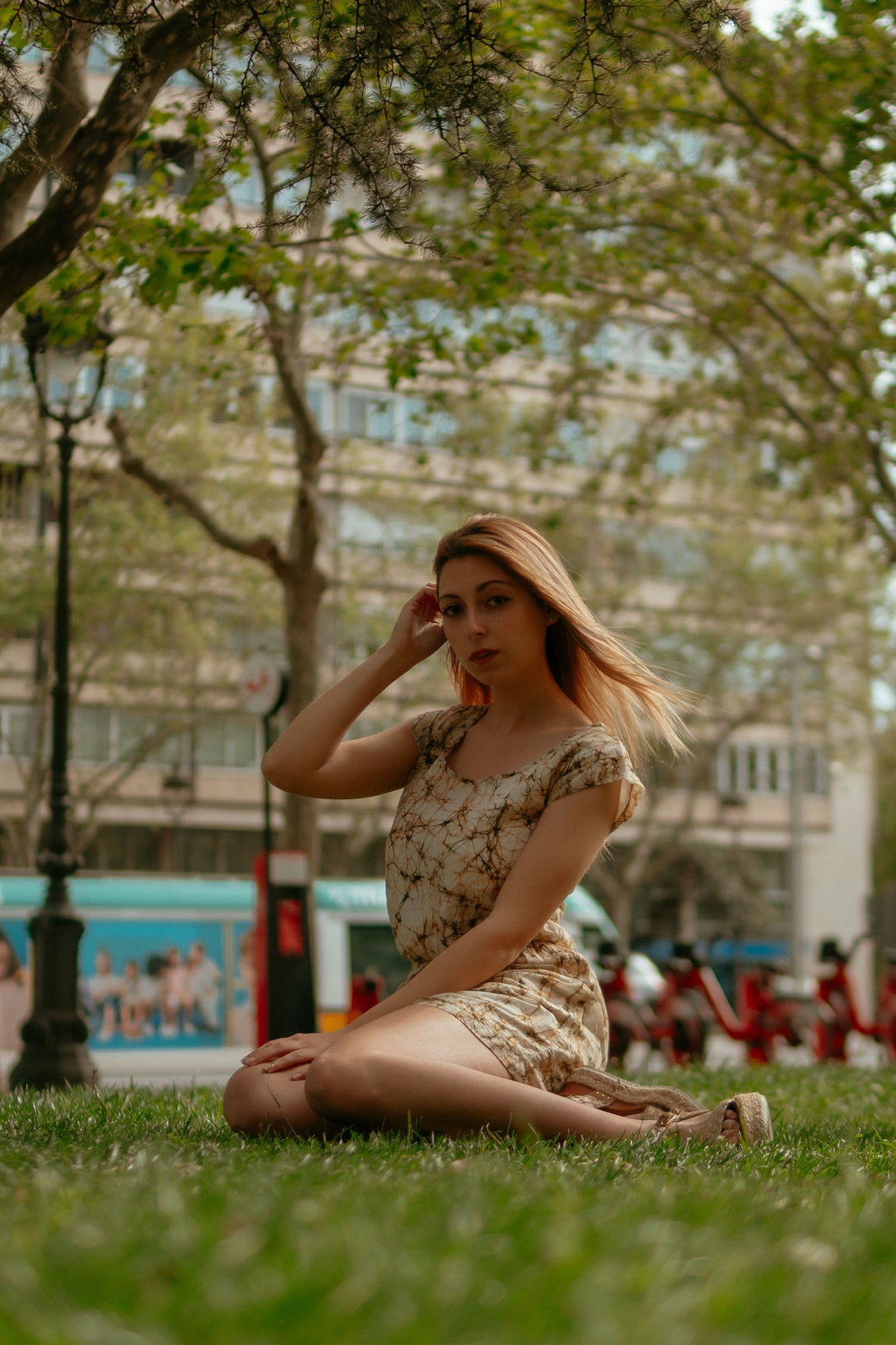 Modelo sentada de perfil con vestido corto Wren, destacando la caída natural y el ajuste favorecedor del vestido