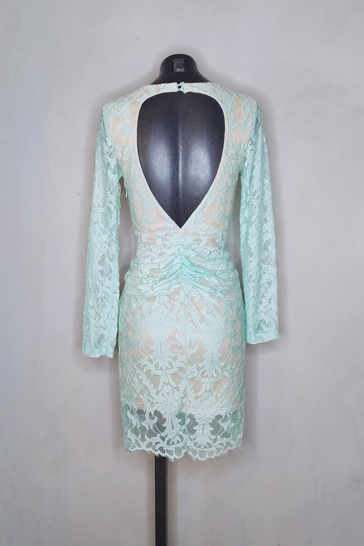 Segunda vista trasera del vestido midi Angel Biba en verde menta colocado en maniquí sobre fondo blanco, resaltando el detalle de espalda abierta