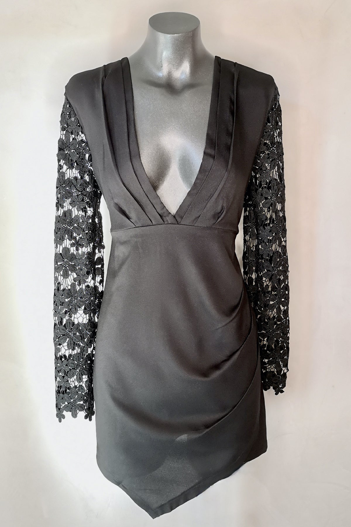 Vista frontal del Reverse Mini Dress de Encaje negro en maniquí mostrando su escote en V y mangas largas