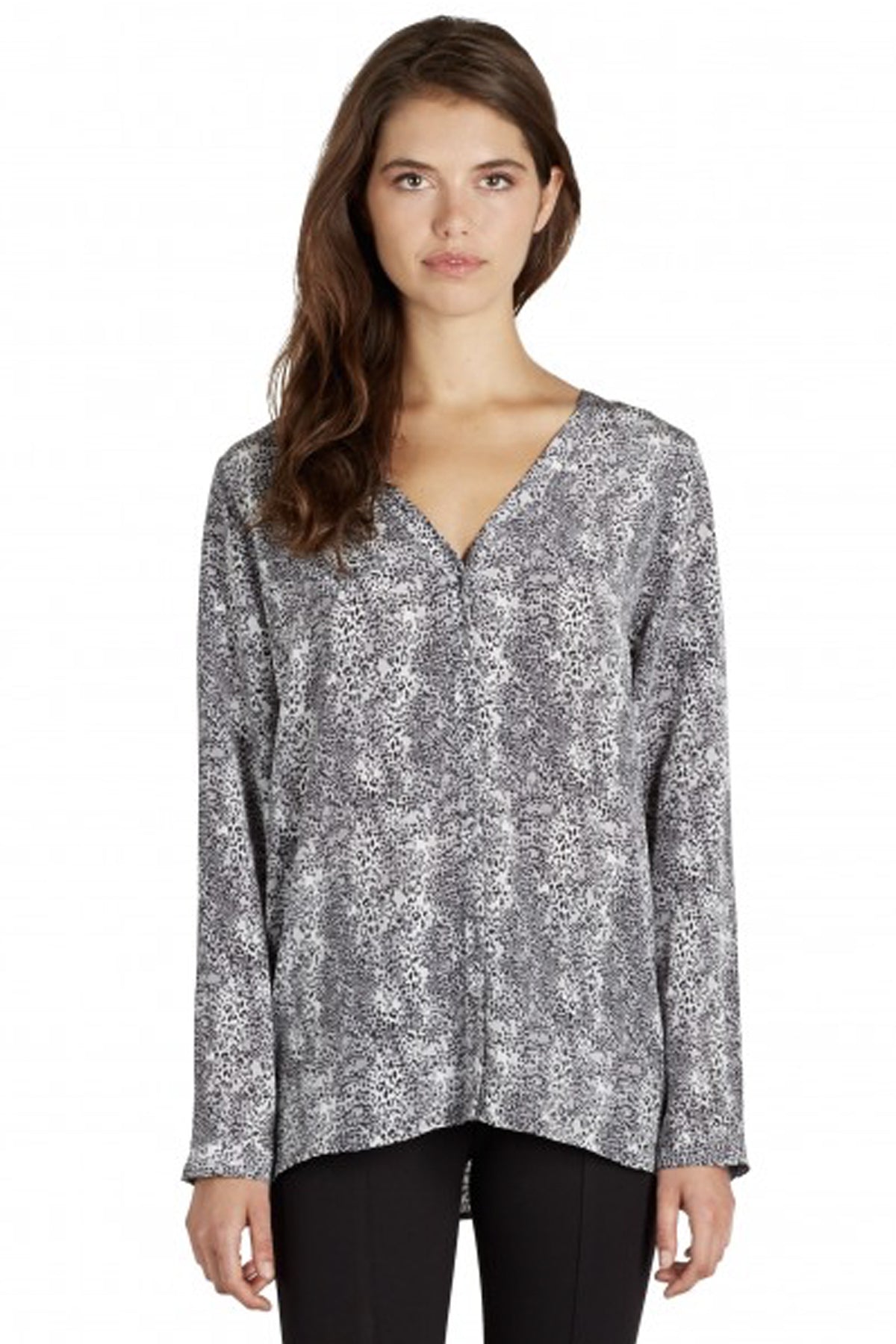 Modelo de frente con blusa Joie Michi en seda estampada cheetah negro, cuello en V y caída fluida ideal para looks sofisticados
