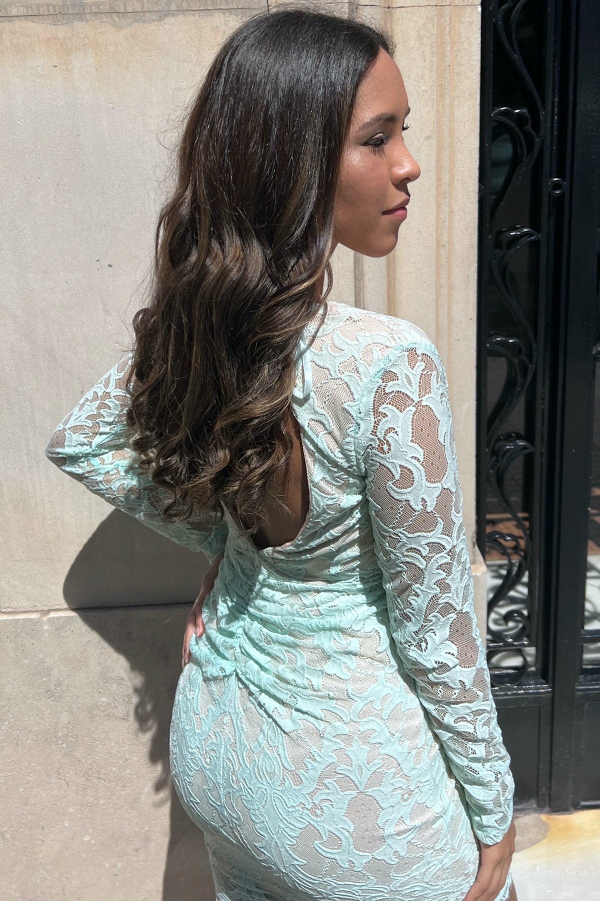 Modelo posando de espaldas con vestido midi Angel Biba verde menta Lace destacando la feminidad de la espalda abierta