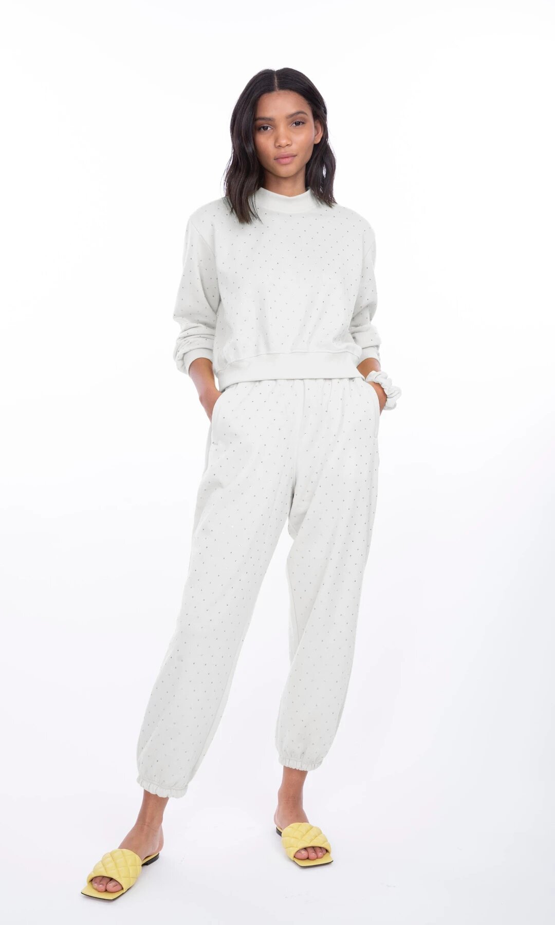 Modelo posando de frente con los pantalones Rena Crystal en blanco, combinando estilo fresco y moderno con caída fluida y cintura alta