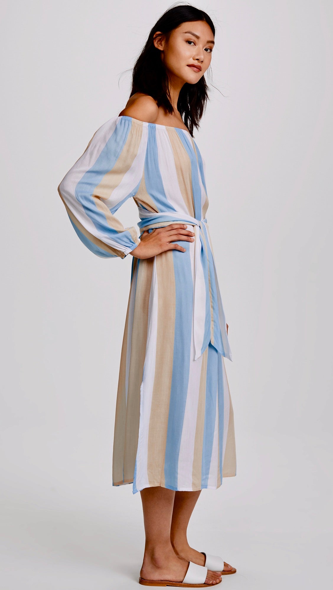 Vista lateral del vestido midi Cool Change Amabella en Angel Blue, destacando su silueta fluida, volante en los hombros y abertura lateral, sobre fondo neutro