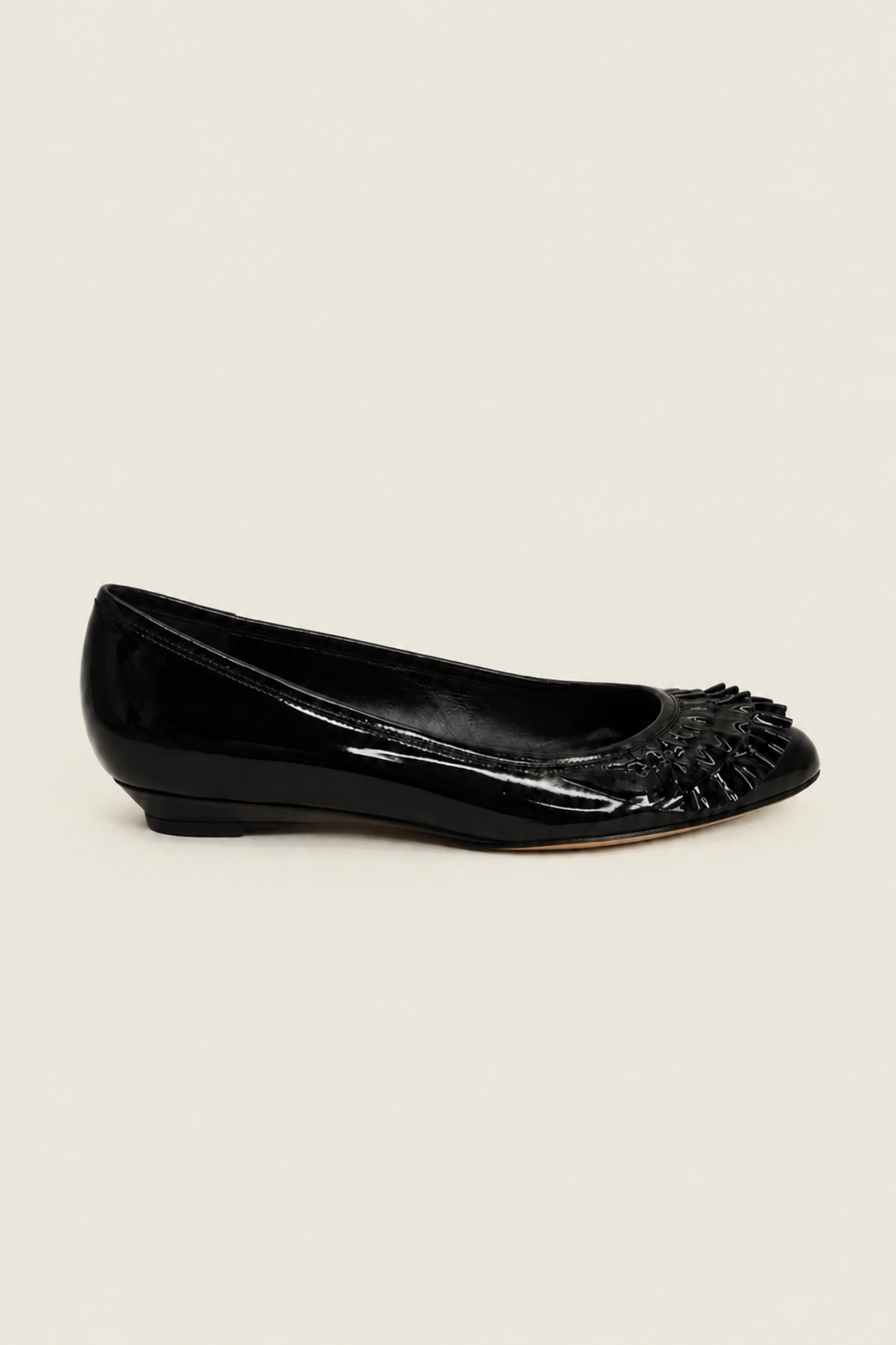 Vista lateral de los zapatos Delphine en charol, destacando su acabado pulido y silueta minimalista perfecta para el día a día