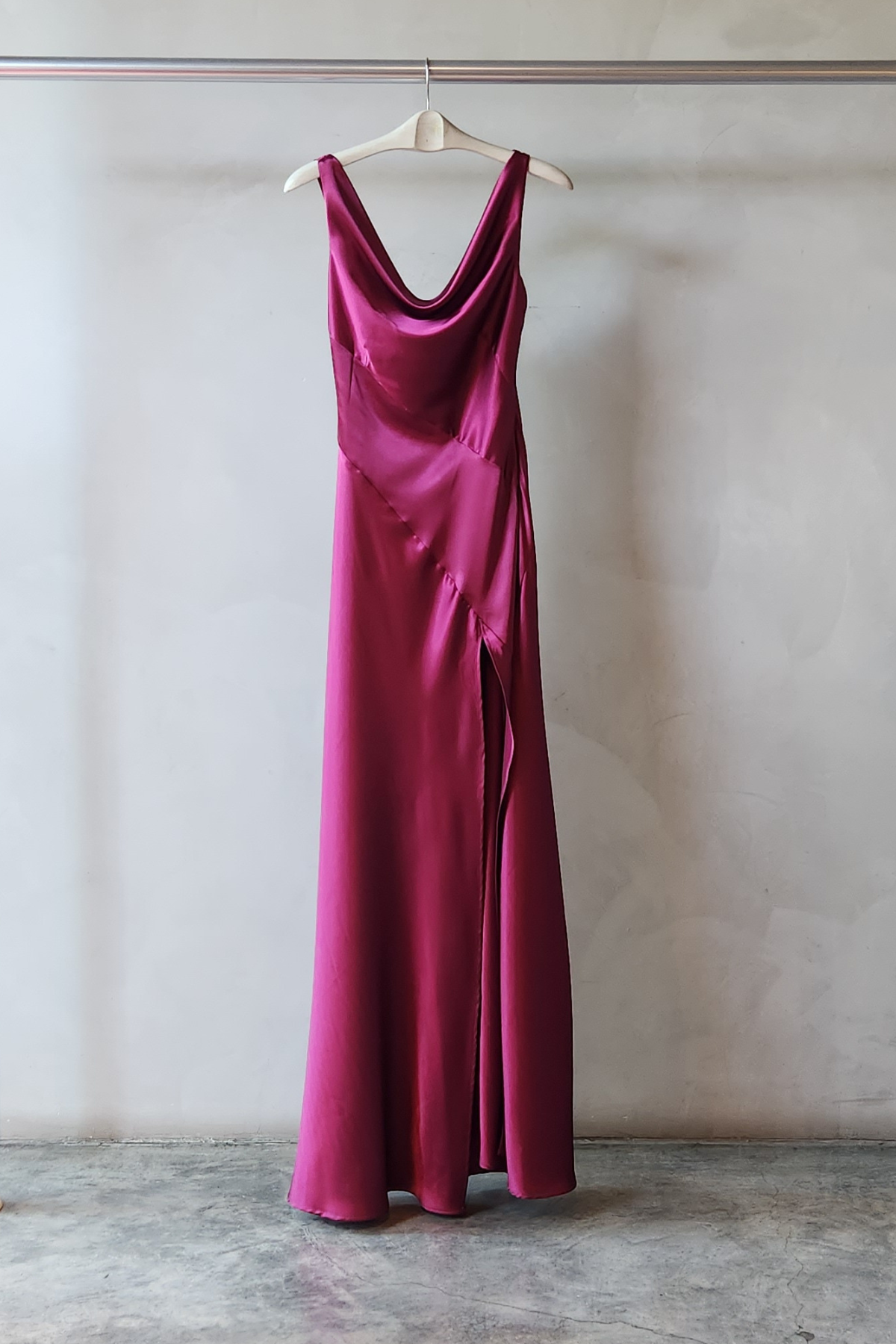 Vestido largo Alfina Granate en raso drapeado con cuello redondo, espalda con lazo, abertura lateral y caída fluida elegante