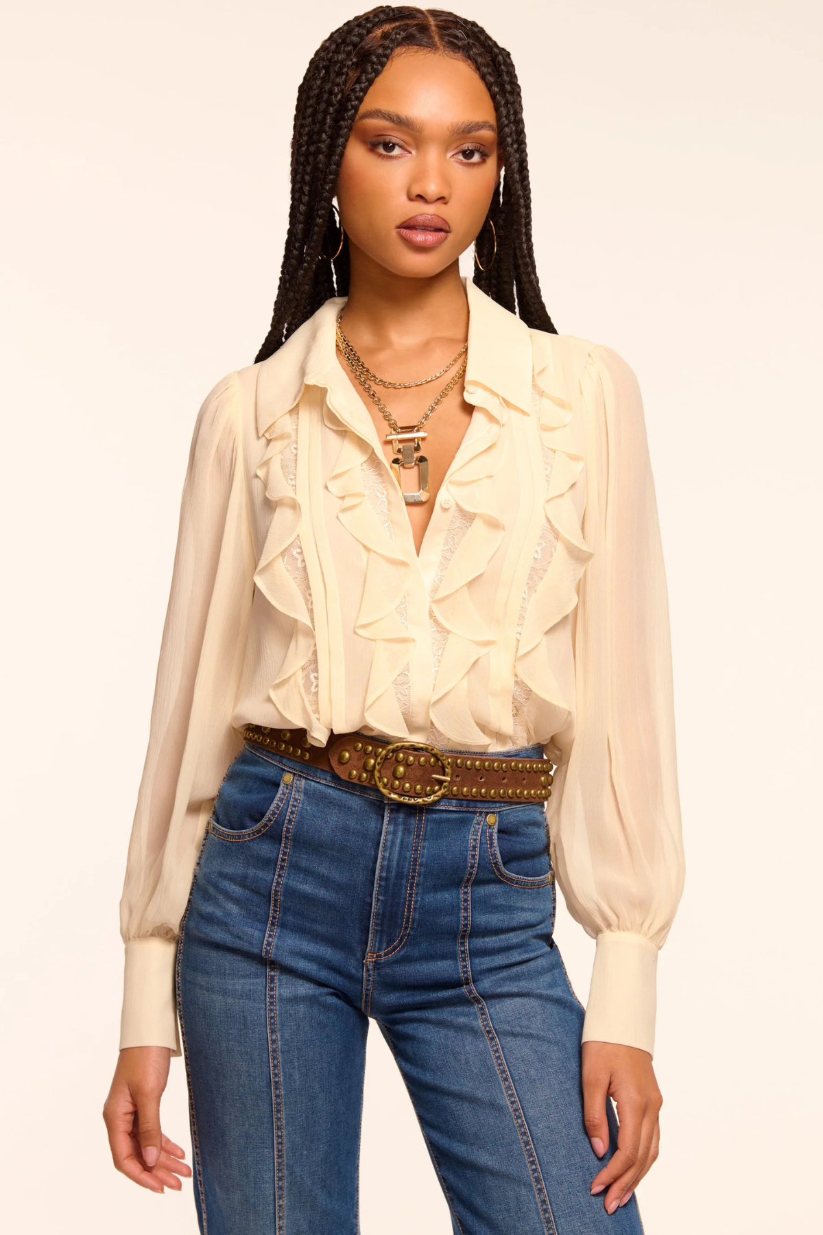 Blusa Claire color bone con paneles de encaje verticales y volantes combinada con jeans para look sofisticado