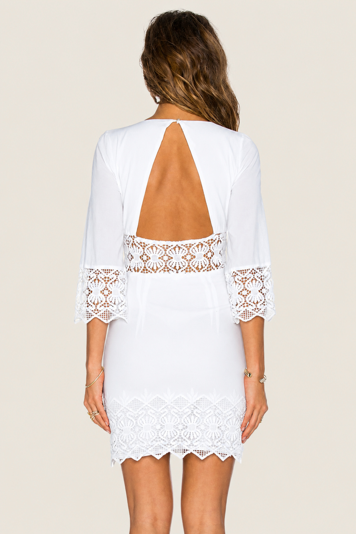Vista trasera de modelo con vestido corto NightCap Tulum Cutout sobre fondo blanco destacando ajuste ceñido y diseño sensual para fiestas estivales