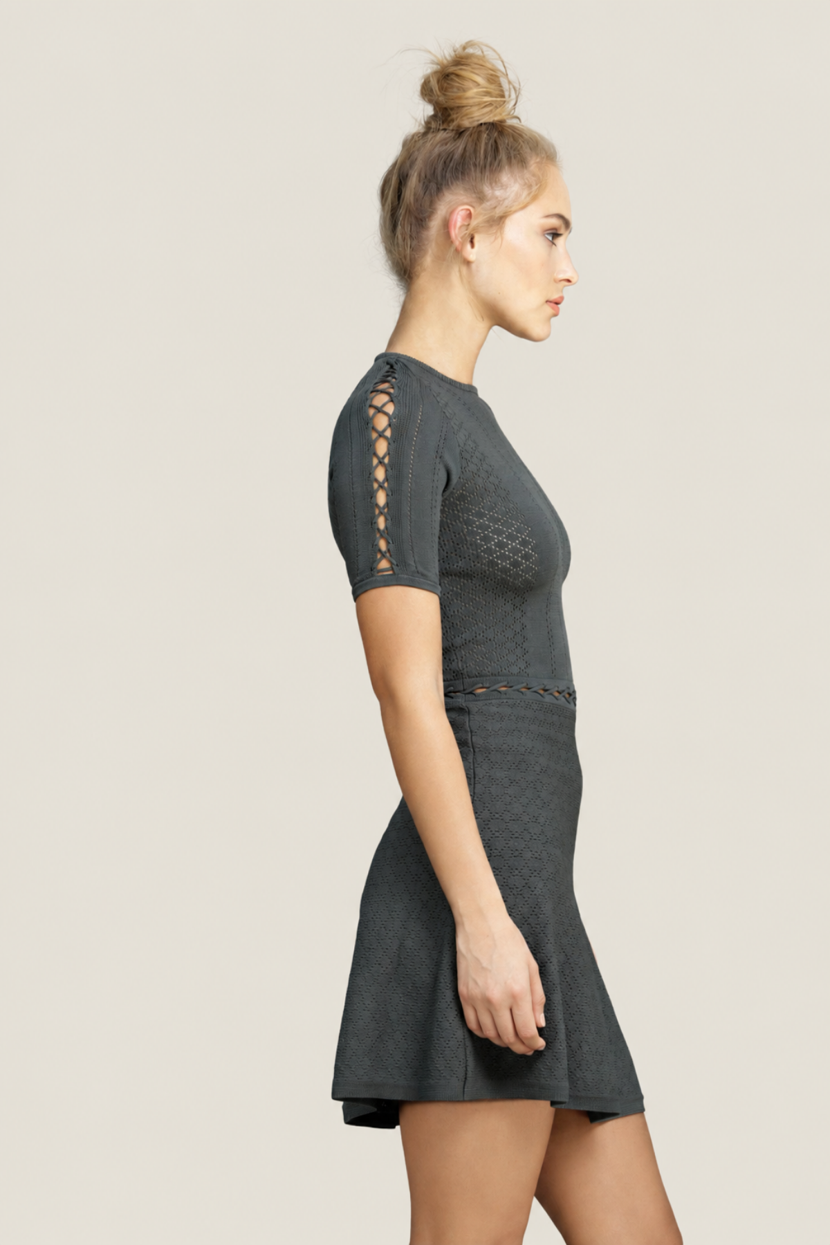 Vista lateral del vestido Alexa mini Fit and Flare oliva en modelo realzando el diseño entallado y la falda con volumen natural