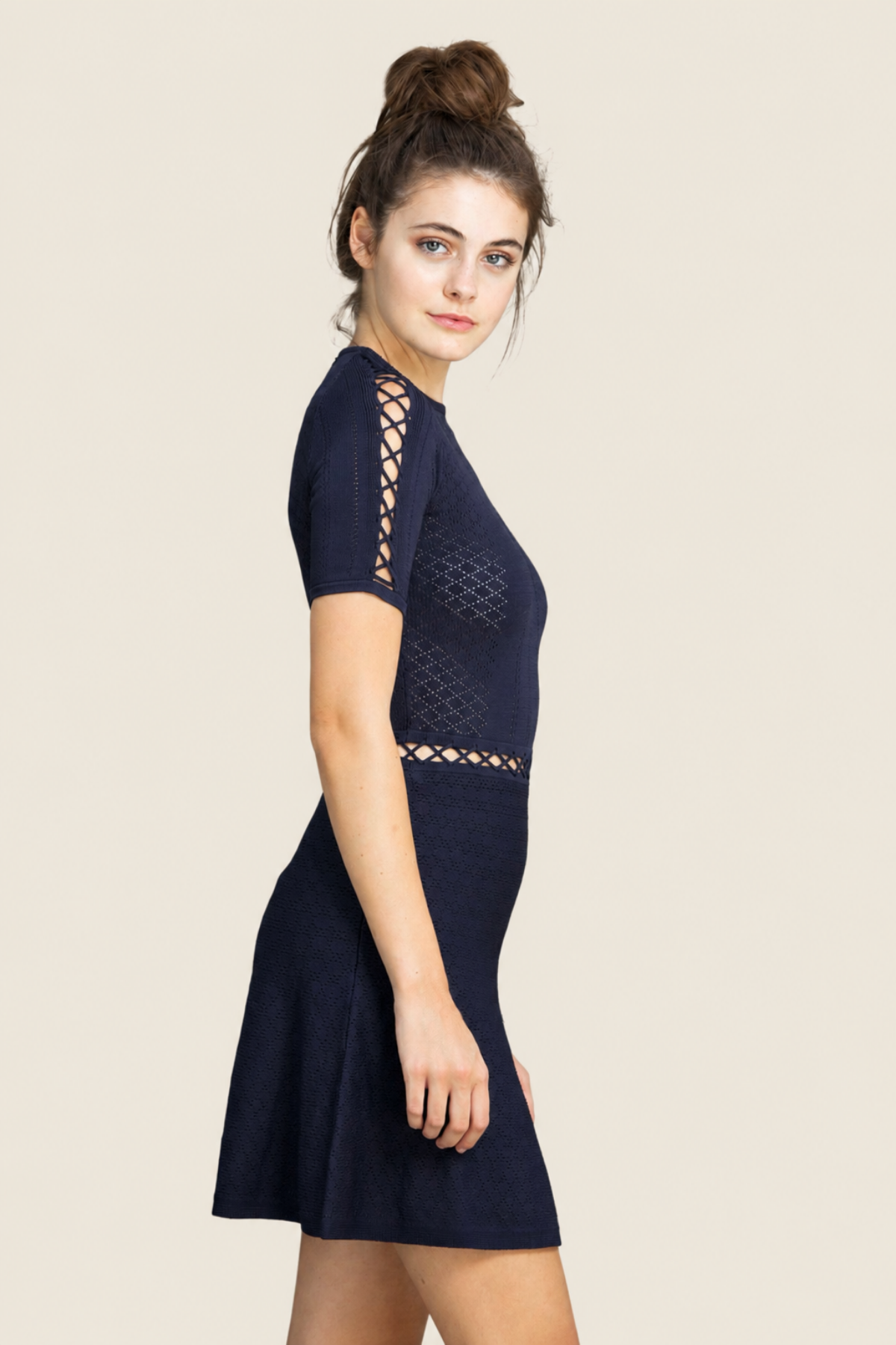 Modelo en vista lateral con vestido Alexa Fit and Flare azul navy resaltando silueta femenina y movimiento de la falda