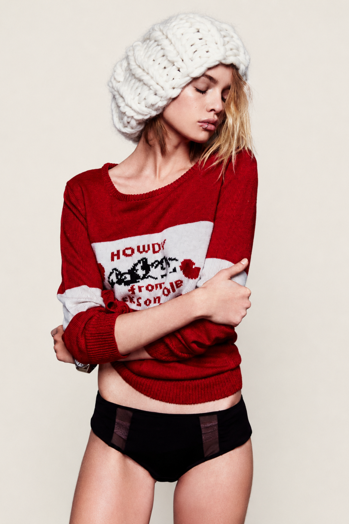 Modelo posando de frente con el jersey Knitz Howdy rojo, con diseño llamativo en el pecho y estilo relajado perfecto para diario