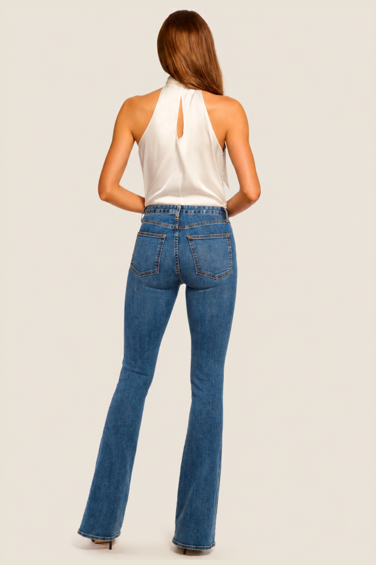 Vista trasera del pantalón flare Medium Wash mostrando los bolsillos, costuras decorativas y caída fluida de la pierna