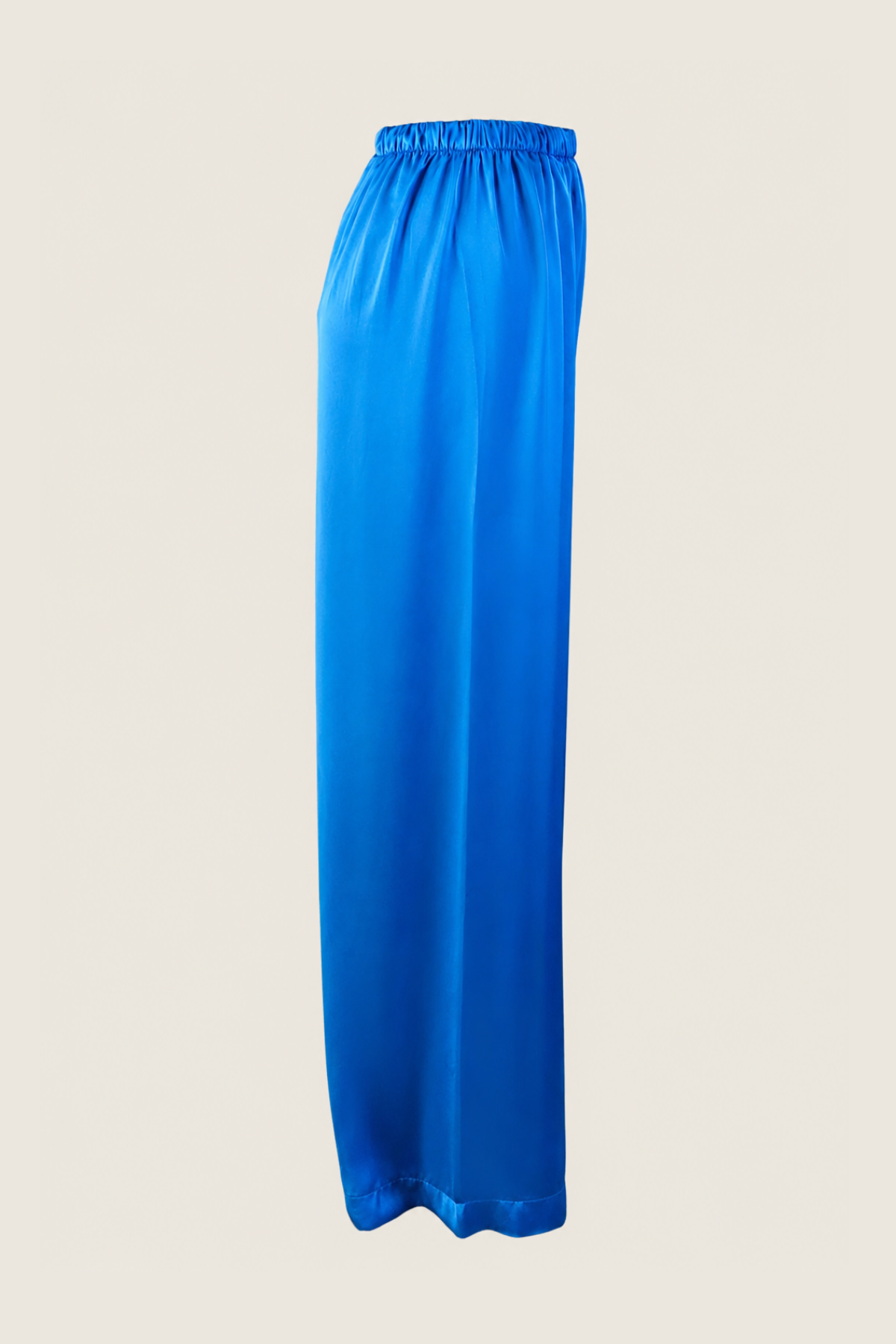 Perfil lateral de pantalones de seda azul con caída ligera y corte fluido que realza la silueta femenina con elegancia natural