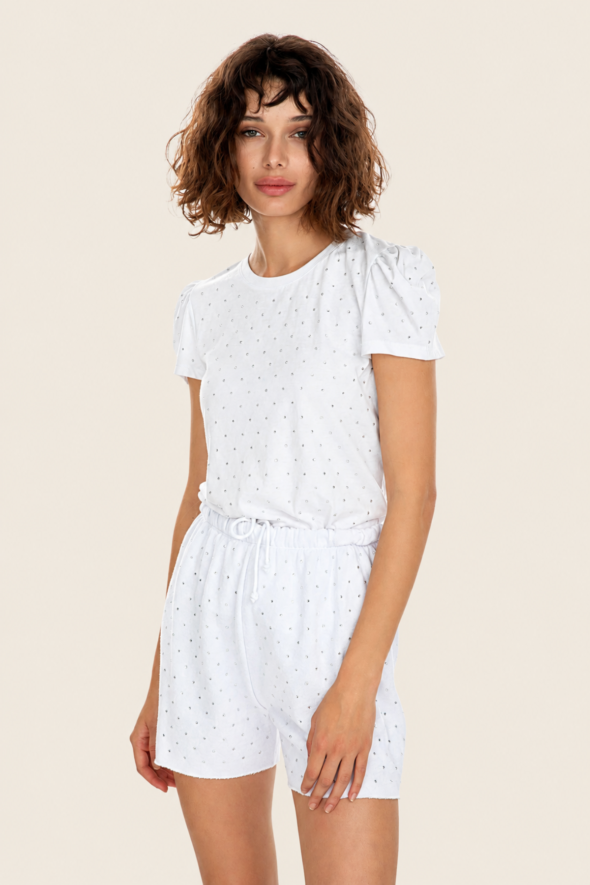 Shorts Aria Crystal blancos con pedrería, modelo de frente en pose relajada, estilo femenino y sofisticado