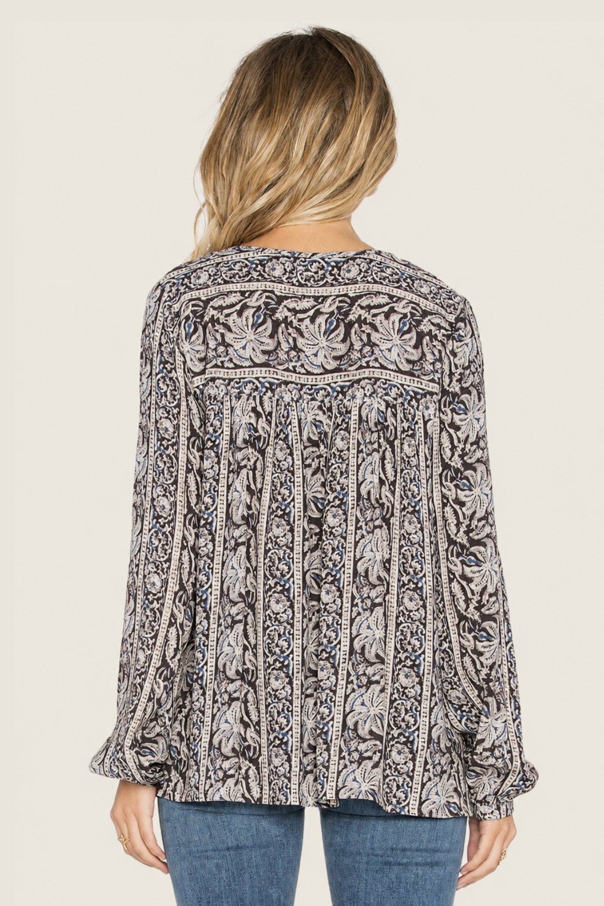 Imagen trasera de modelo con blusa negra Sunset Meadow, mostrando lazo ajustable y diseño elegante en fondo blanco limpio y minimalista