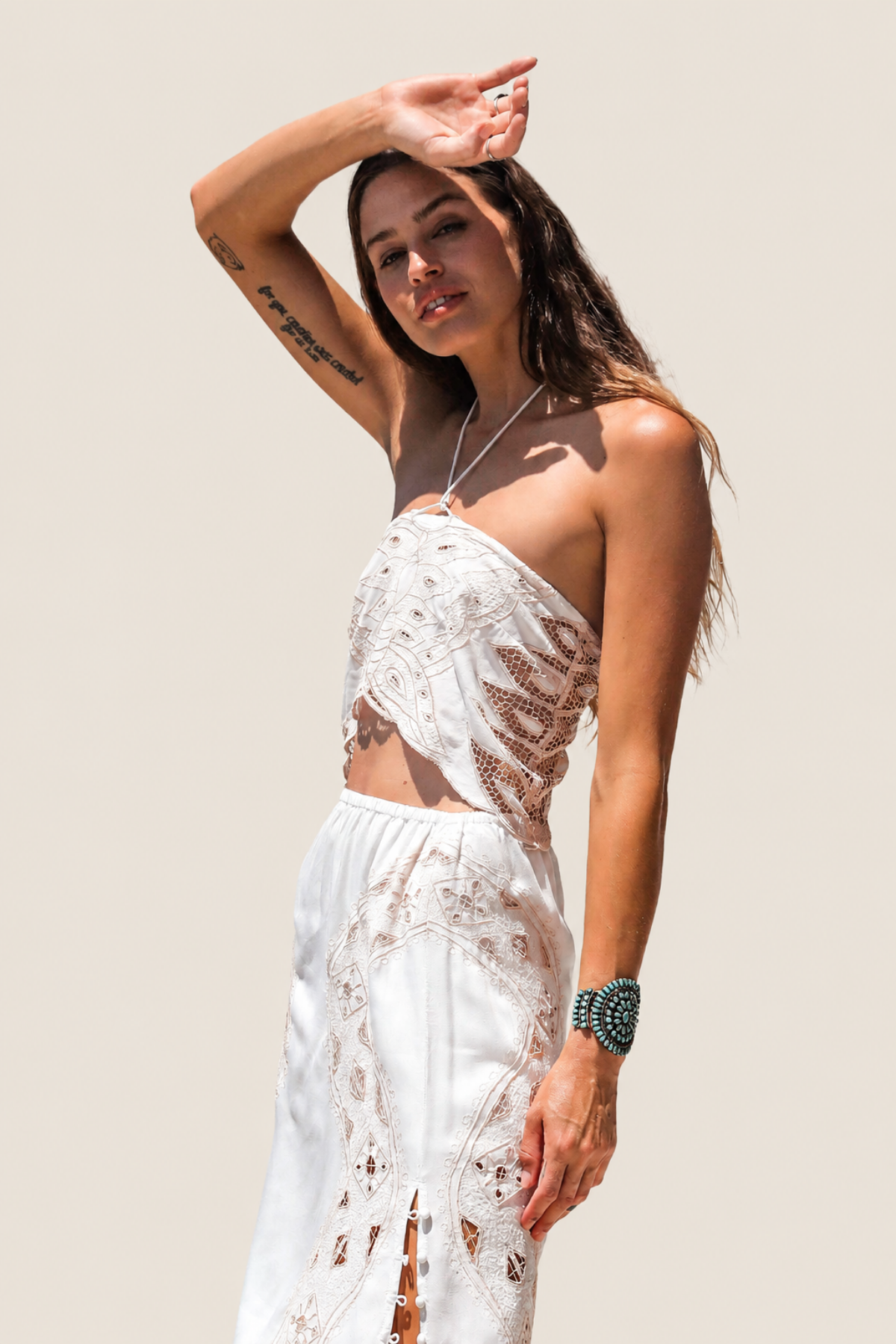 Modelo de frente con Dolly Crop Top color Western Bone con bordado de mariposa y tirante halter ajustable para estilo boho festival