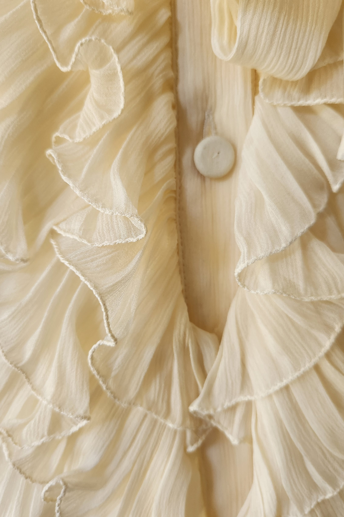 Primer plano volantes blusa Luisa Becaria ivory mostrando confección italiana artesanal y movimiento fluido femenino