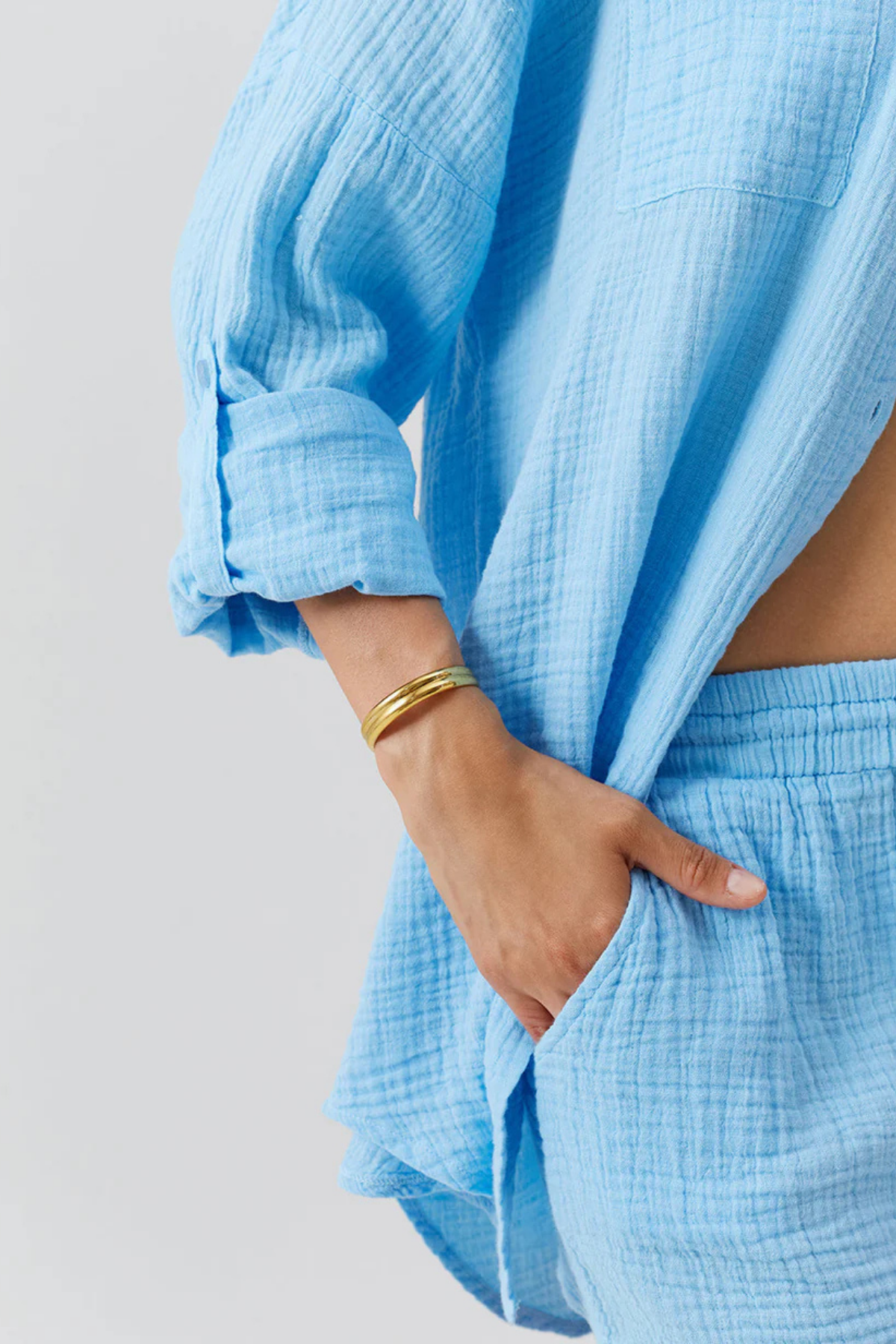 Detalle de cintura fruncida con cordón ajustable y terminales dorados sobre shorts oasis