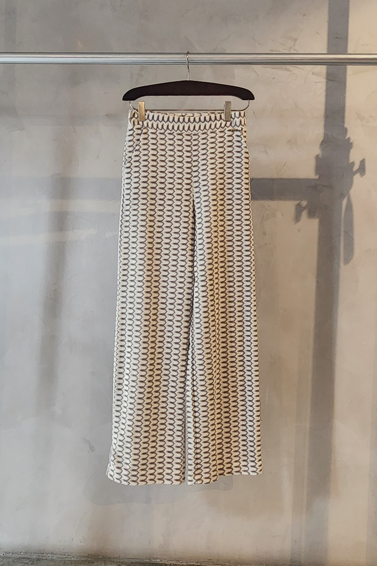 Pantalón Charme Pho Firenze con estampado de rayas verticales colgado en percha mostrando pernera ancha fluida elegante