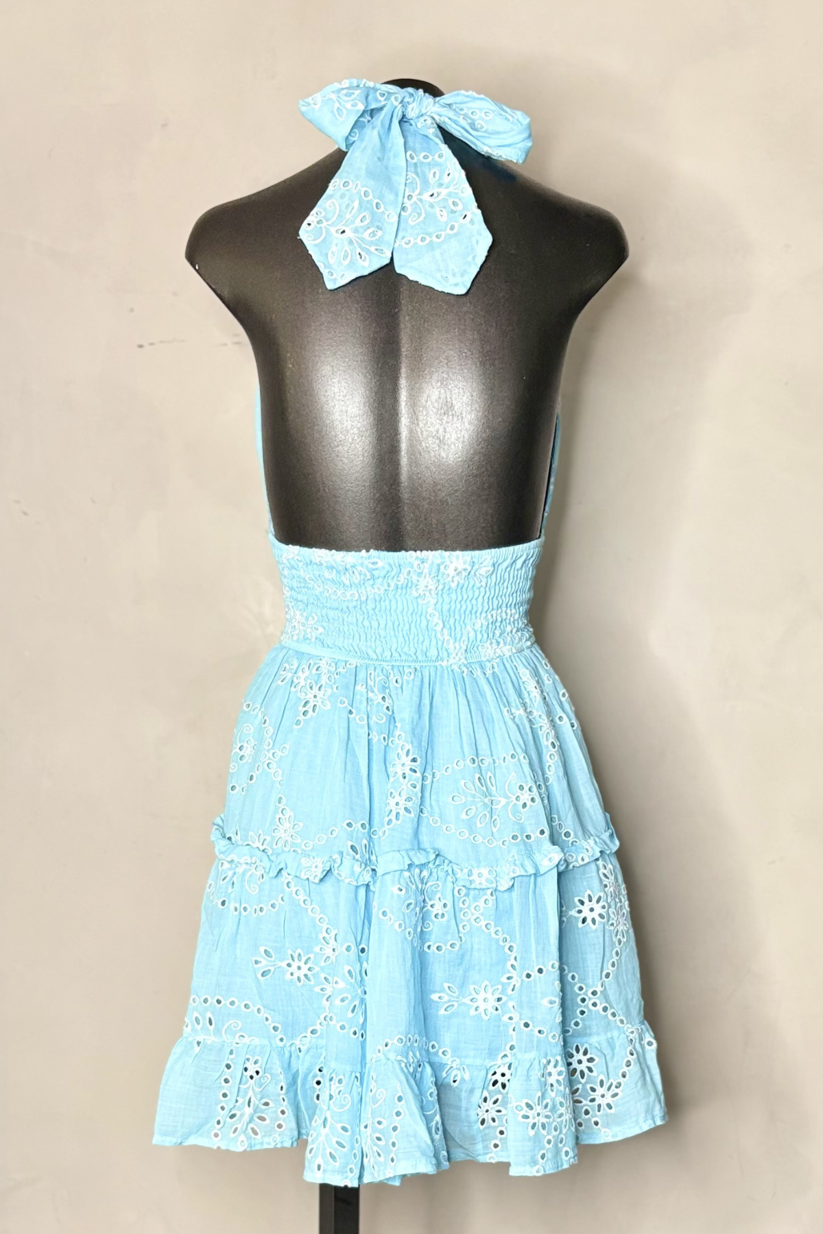 Vista trasera vestido corto  con silueta favorecedora y diseño romántico perfecto para vacaciones y eventos de verano