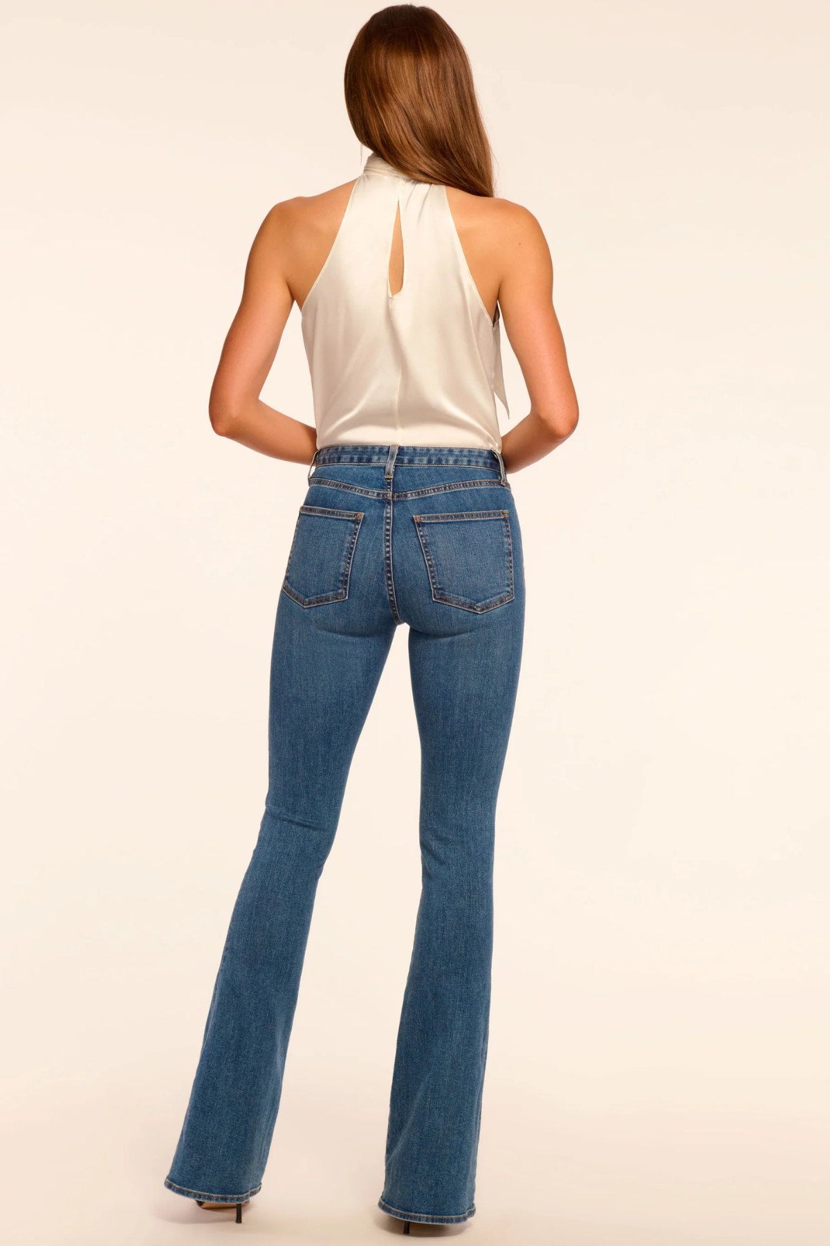 Vista trasera del pantalón flare Medium Wash mostrando los bolsillos, costuras decorativas y caída fluida de la pierna