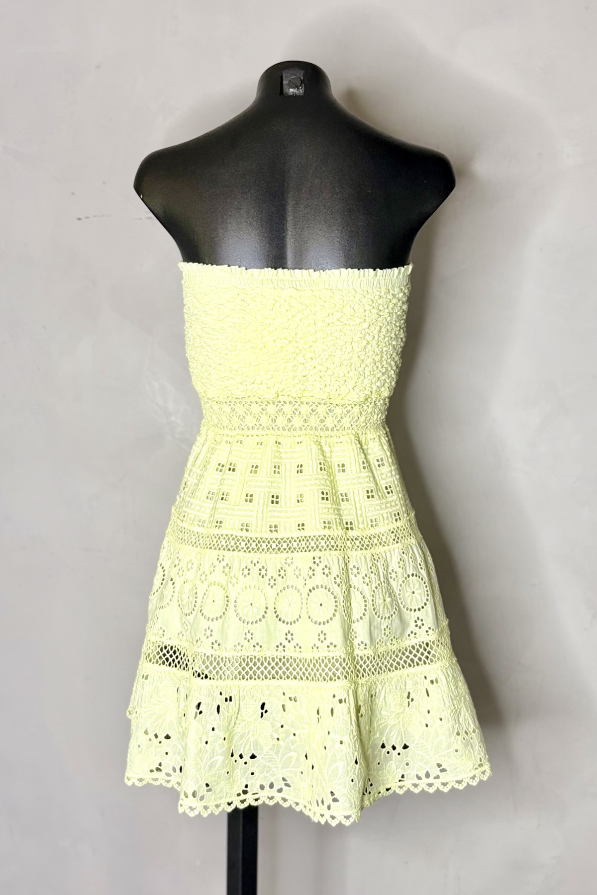 Vista trasera vestido corto giallo con silueta fluida y diseño femenino perfecto para vacaciones, paseos y eventos de verano