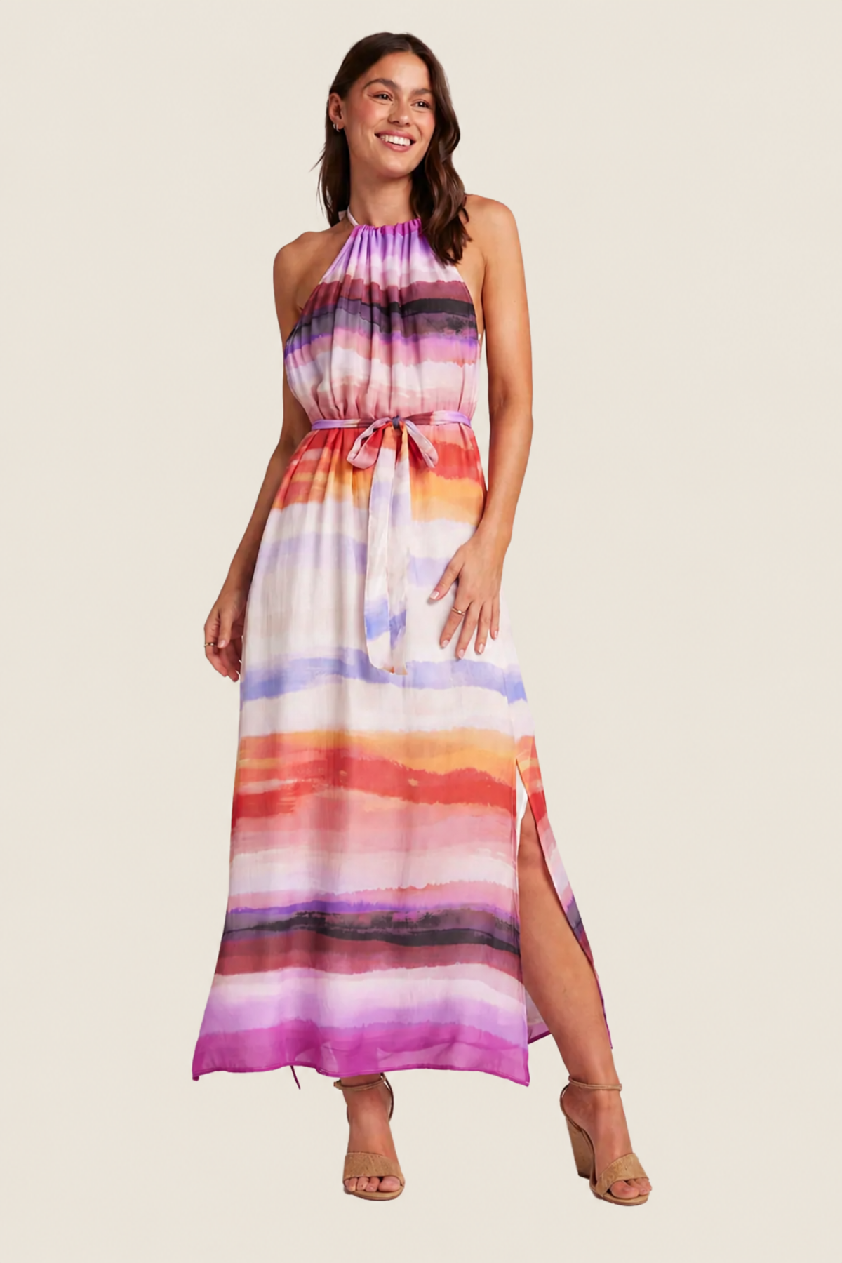 Modelo posando con vestido midi Bella Dahl en rayas multicolor, mostrando escote halter y cintura fruncida, sobre fondo blanco
