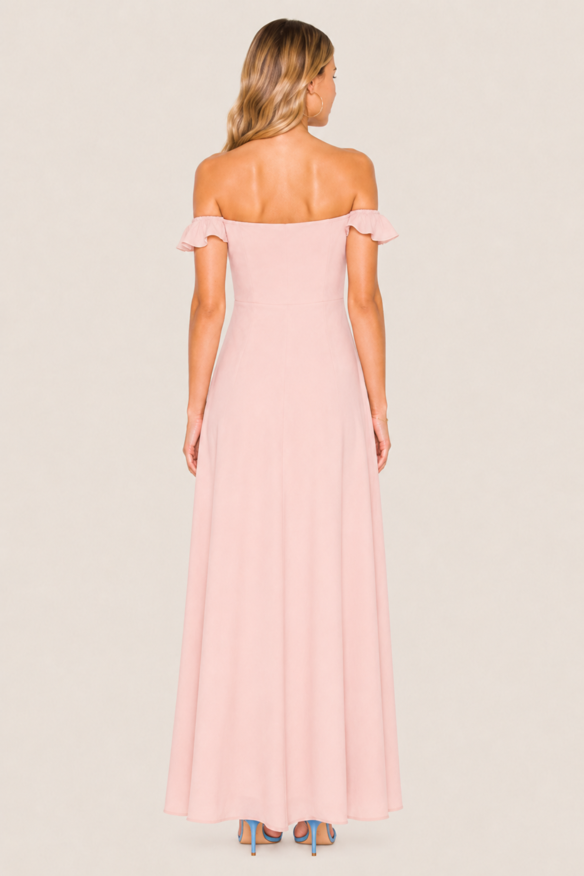 Vista trasera de la modelo con vestido Bardot Sweet Cherry Pie rosa, mostrando espalda descubierta y tirantes de volantes sobre fondo blanco