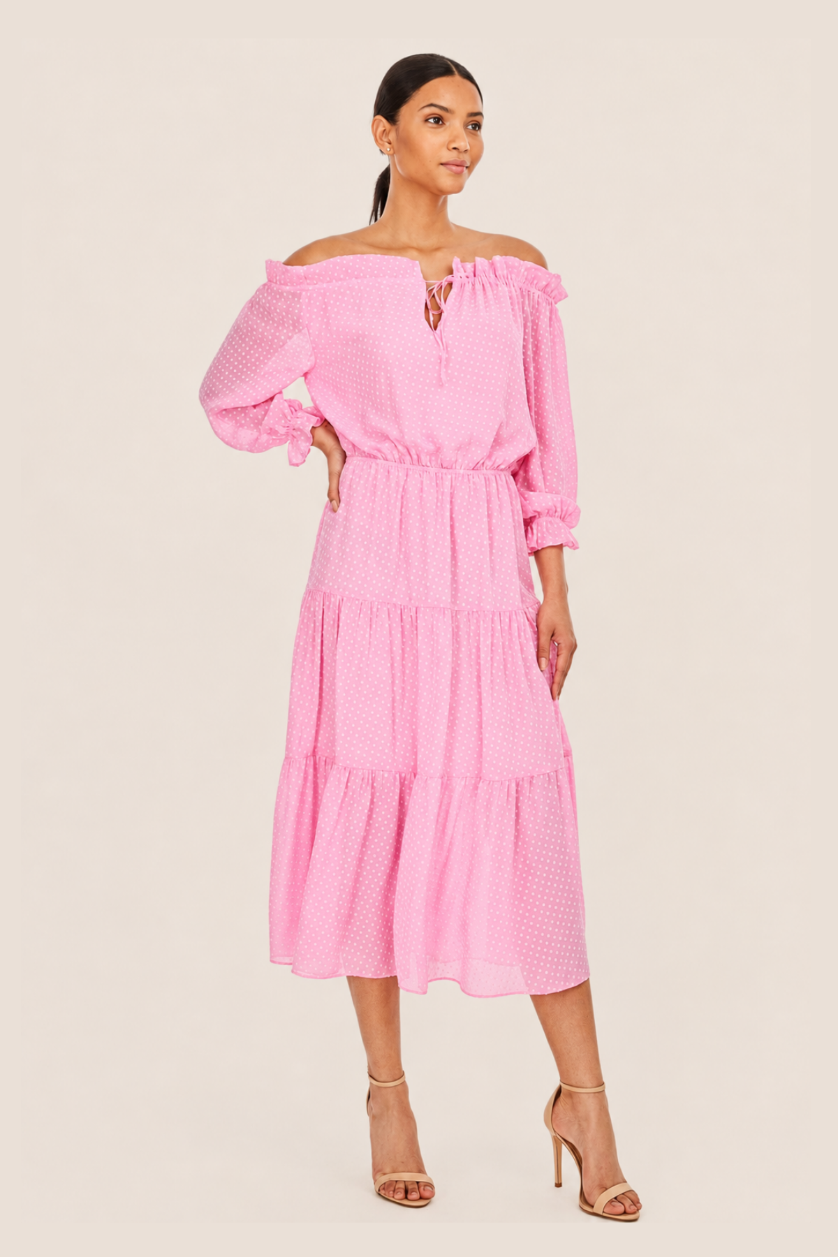 Primer plano del escote en V y hombros descubiertos del vestido Leoni Candy Pink, con cierre de lazo y detalle de plumetti.