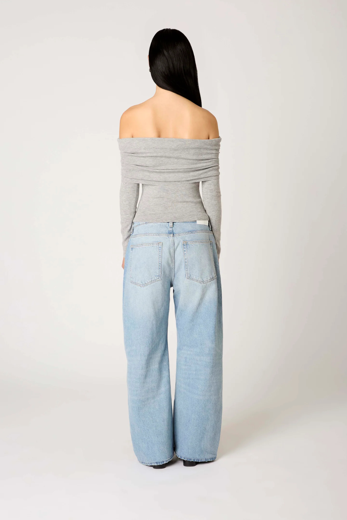Vista trasera del suéter Islay Heather Grey para mujer, mostrando el corte relajado, la caída del tejido de punto y el estilo cómodo