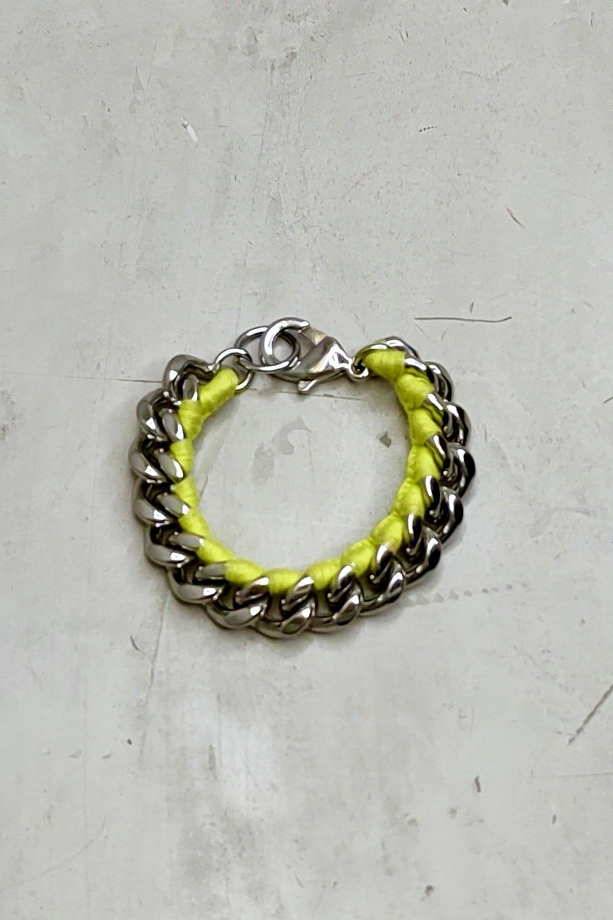 Pulsera de cadena en neón amarillo con eslabones grandes sobre fondo blanco, diseño moderno y vibrante para un estilo atrevido